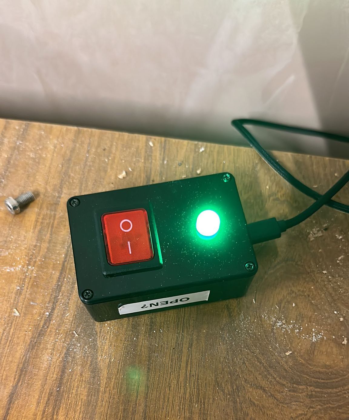 A picture of the Hackspace State switch, with its LED glowing green, indicating that it is open.